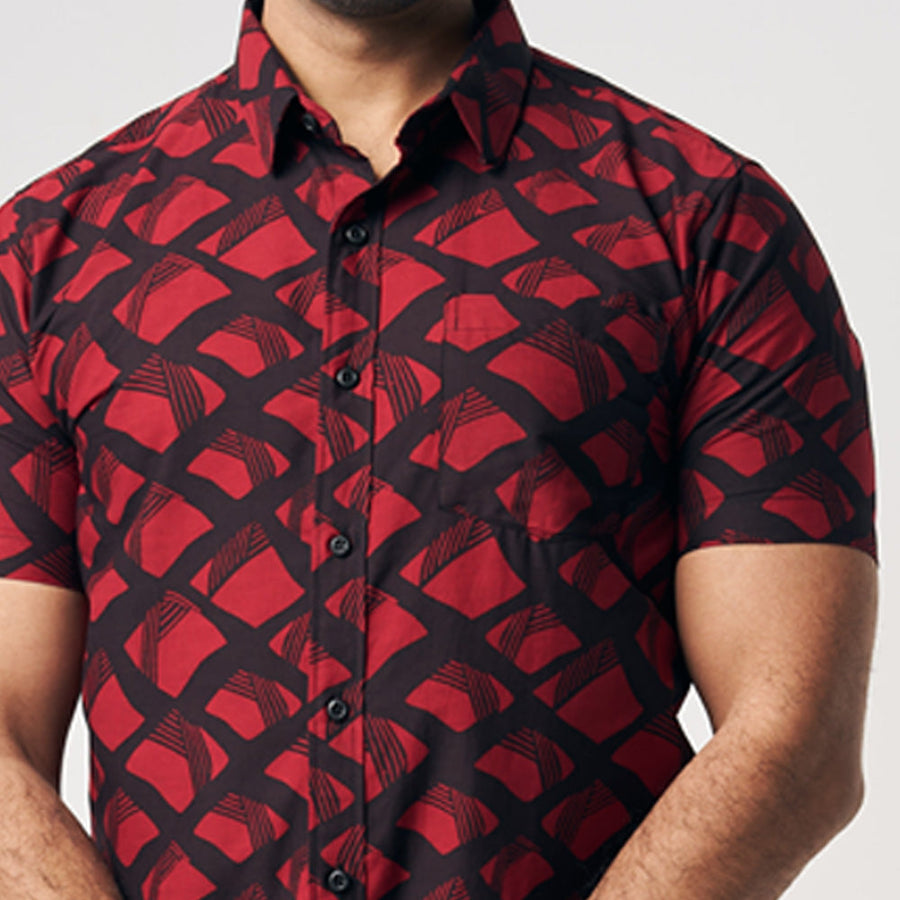 A closeup photo showing button on cotton short sleeve shirt in Red Nasi Lemak, which is black and red color. Batik shirt is handcrafted by skilled artisans