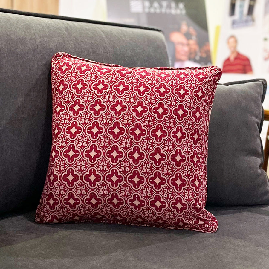 A lifestyle photo of pillow cover in crimson celestial design pattern. On grey sofa