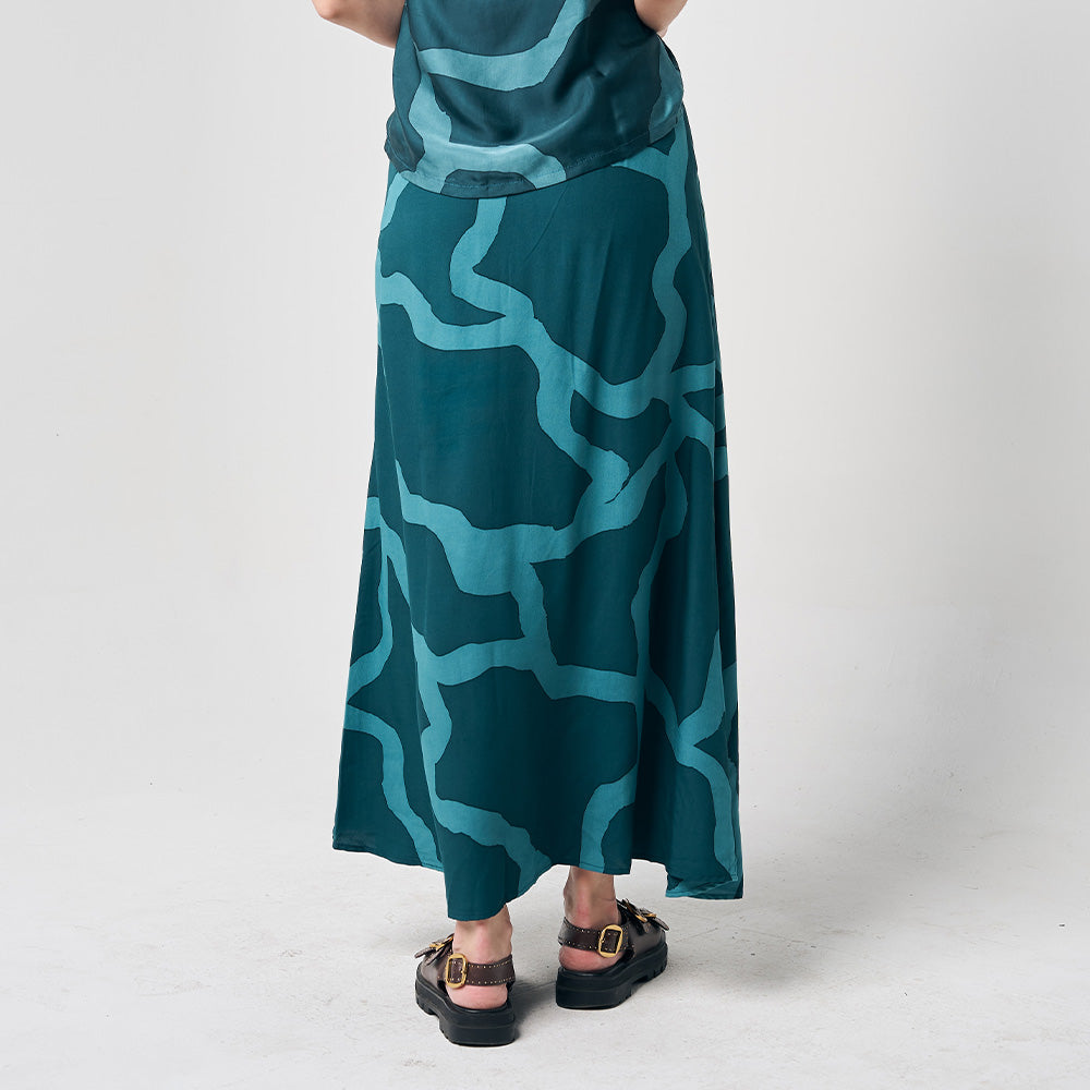 A stylish back view of a long batik skirt, featuring the enchanting Forest Chain pattern, against a neutral background, highlighting the graceful design