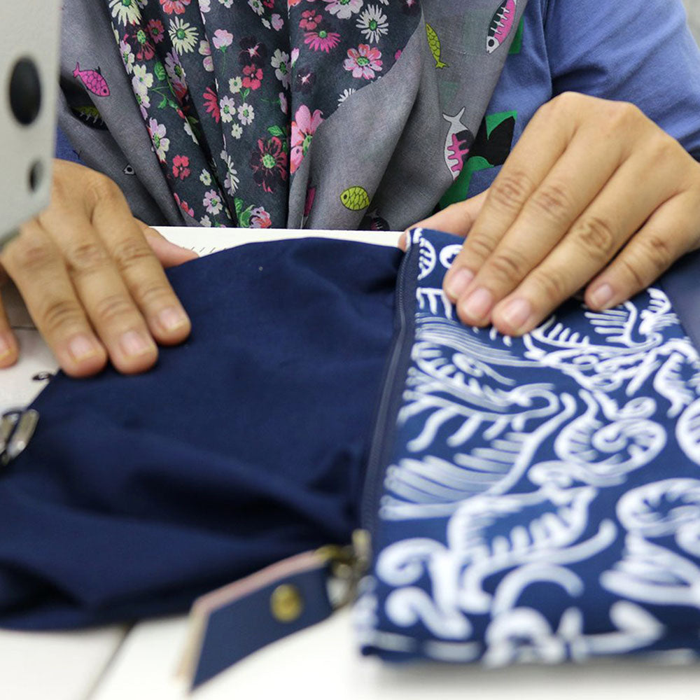 a photo of a seamstress holding batik zip pouch