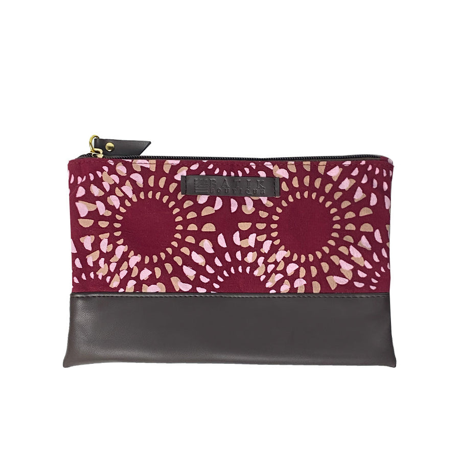 A picture of a handcrafted batik zip pouch with a leather front featuring the sewn-on Batik Boutique logo, adding an exclusive touch to the design