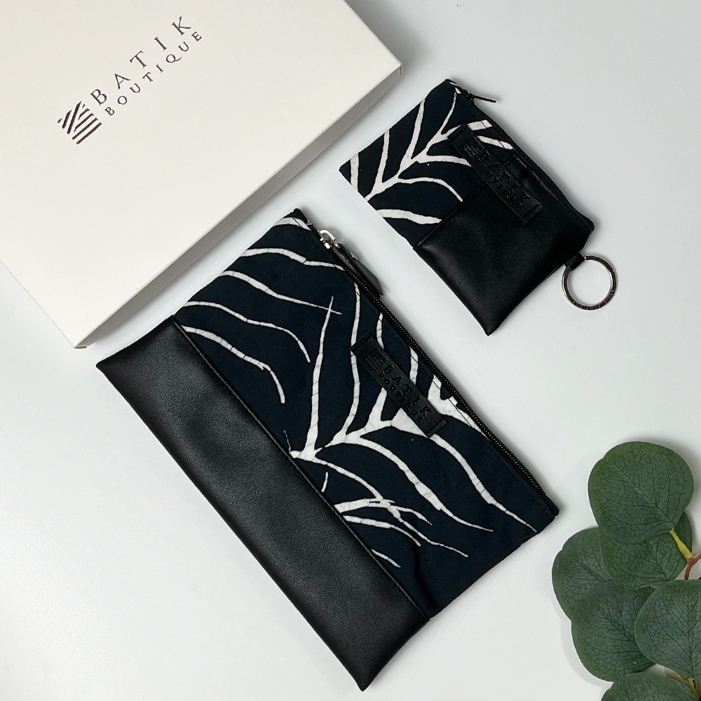 a picture of a flatlay in a black fern pattern made of batik against a neutral background