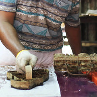 An artisan skillfully engaged in the batik-making process, using the traditional blocking technique