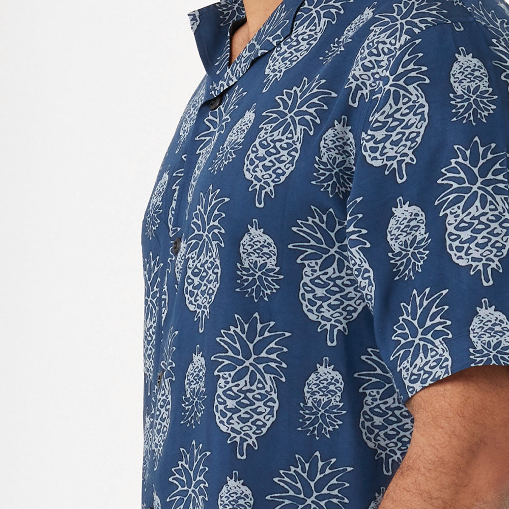 a close up photo of man wearing and styling batik cuban shirt in pineapple motif