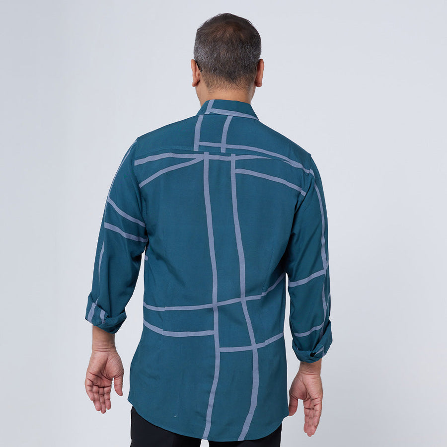 Back view of a man wearing and showcasing the long-sleeved batik shirt in Forest Green