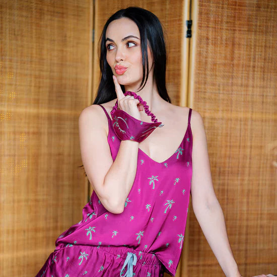 A lifestyle photo of women pouting her lips and wearing batik camisole and shorts in fuchsia palm silk material
