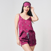 A photo of model wearing silk cotton camisole and shorts in pink color, Fuchsia Palm print. Complete with eyemask as a gift set for her