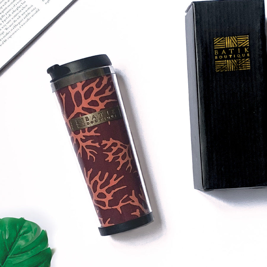 a maroon coral tumbler made of batik in a lifestyle photo