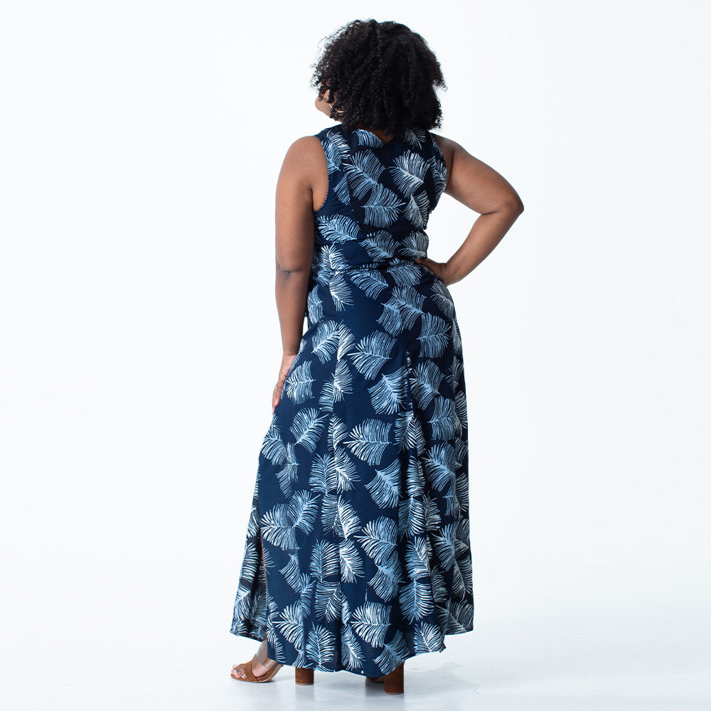 a women standing in front of white wall while styling batik maxi dress in navy sawit