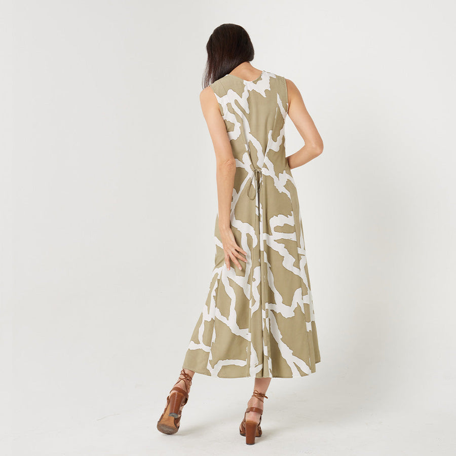 a woman standing in front of white background styling batik long maxi dress in stone chain pattern