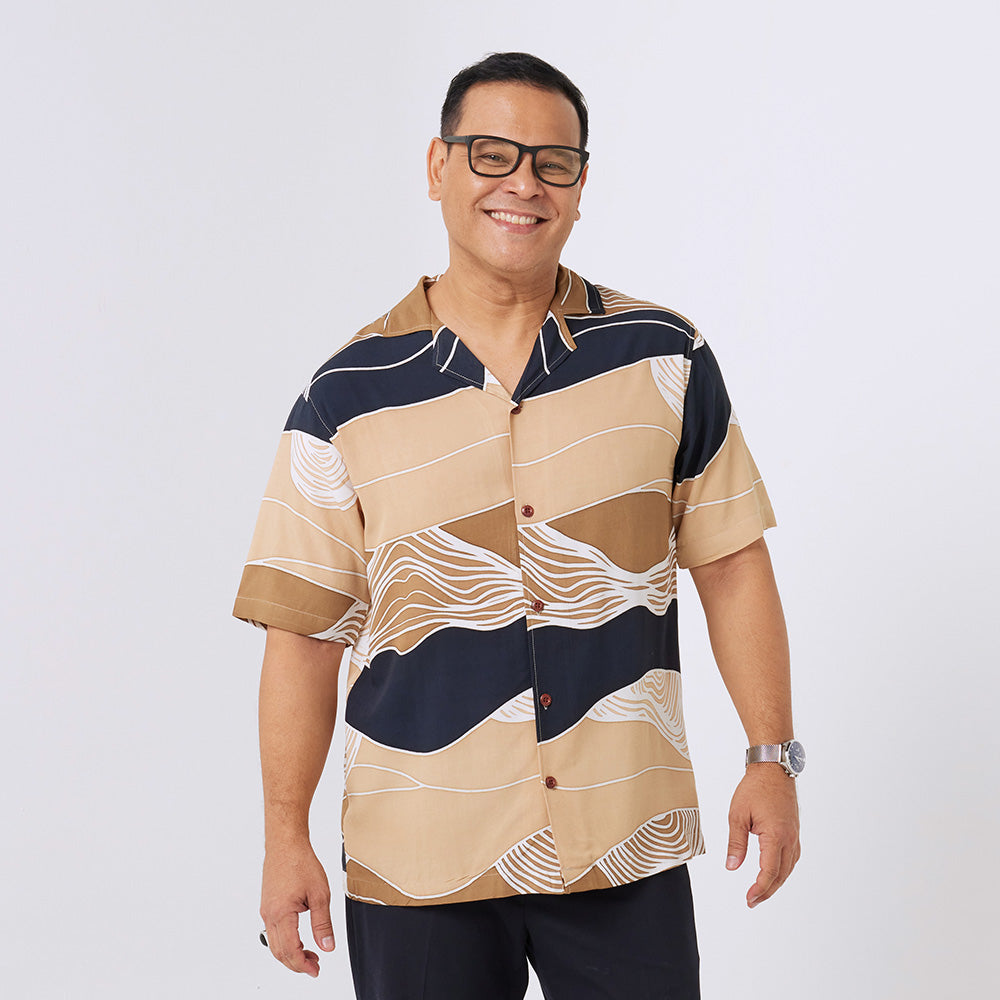 a man standing in front of white background styling batik cuban shirt in black bukit pattern 