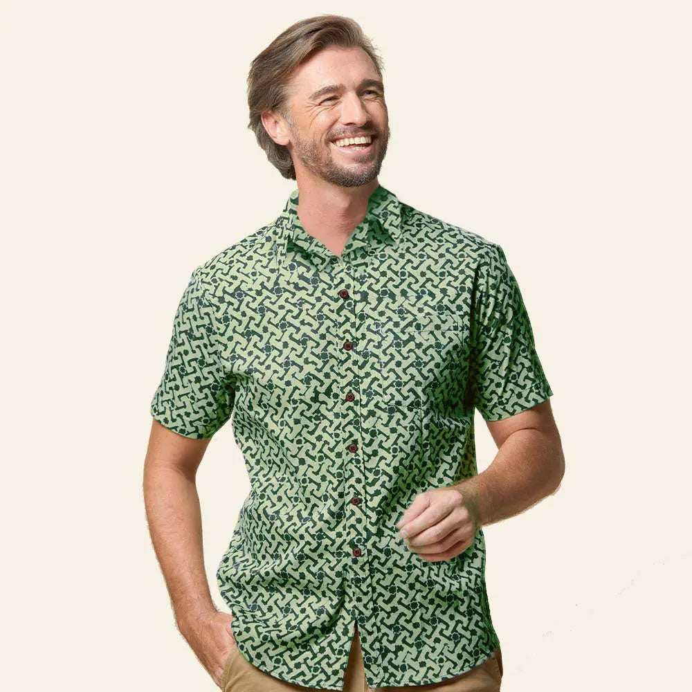 In a whitebox photo, a male model confidently strikes a pose against a neutral backdrop, showcasing a stylish batik shirt adorned with the captivating Forest Arabesque pattern