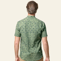 A male model confidently showcasing the exquisite details of the Forest Arabesque batik shirt with his back to the camera, set against a neutral background