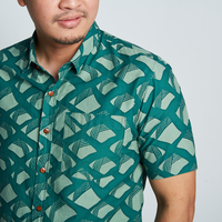 a closeup shot showcasing the details on a batik shirt in the pattern green nasi lemak against a neutral background
