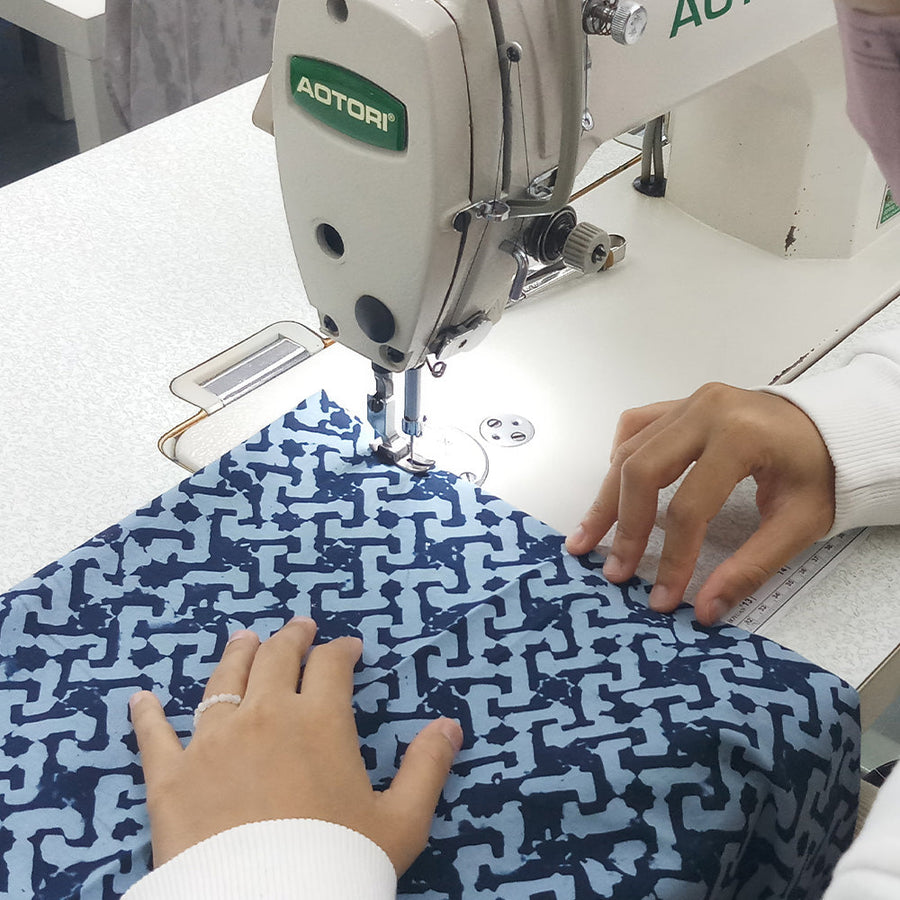 artisan sewing batik fabric in midnight arabesque