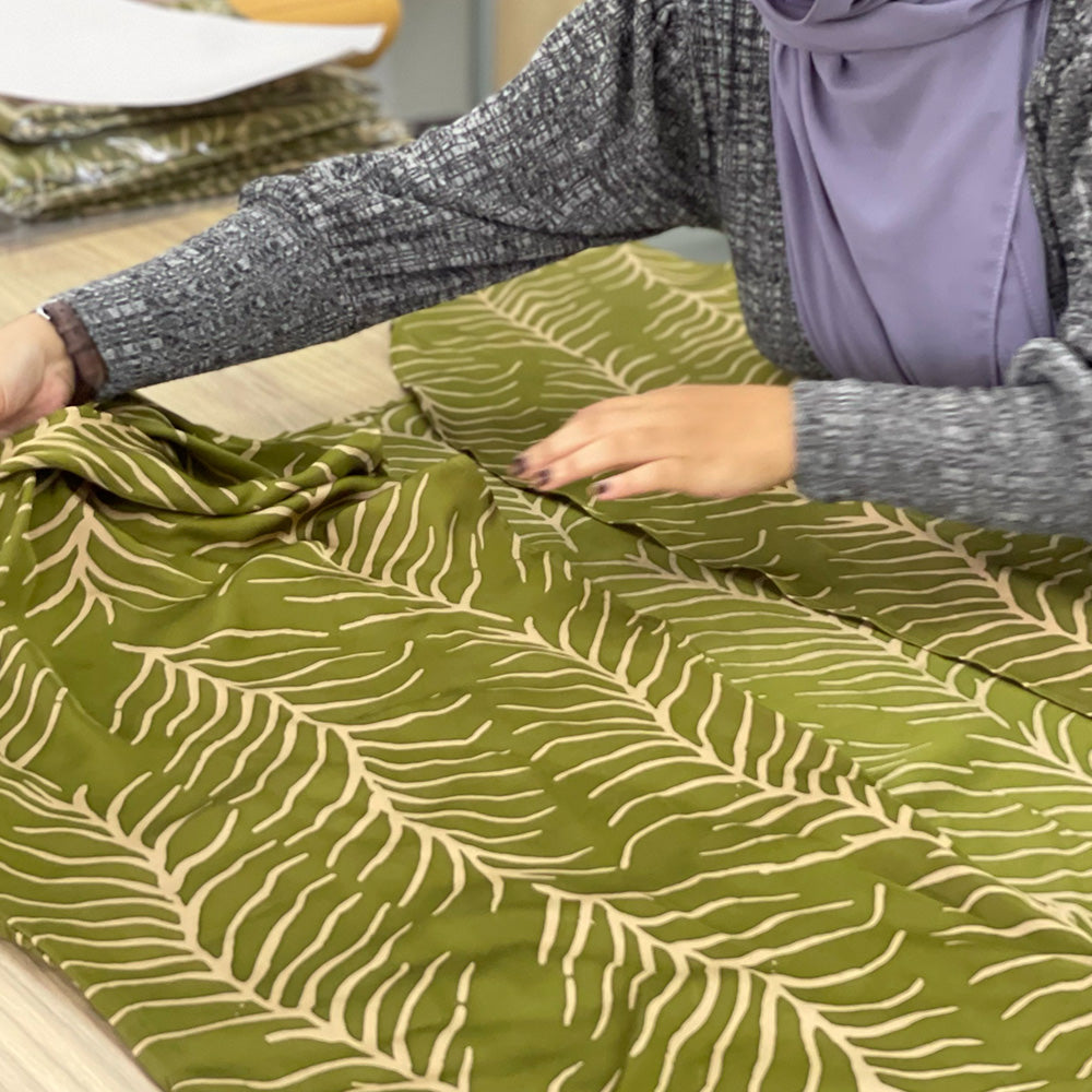 An artisan is preparing to cut batik kimono in moss fern