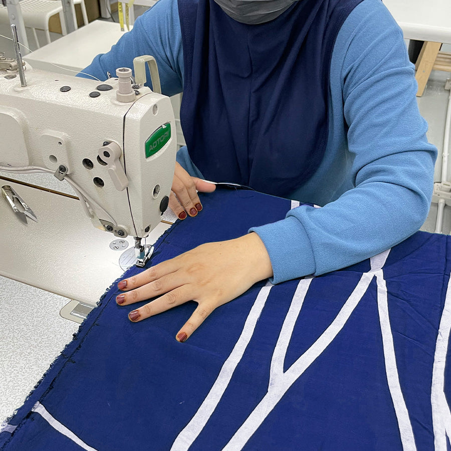 artisans sewing batik fabric in navy brush