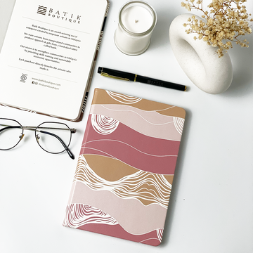 A lifestyle photo of batik inspired notebook in dawn bukit pattern.