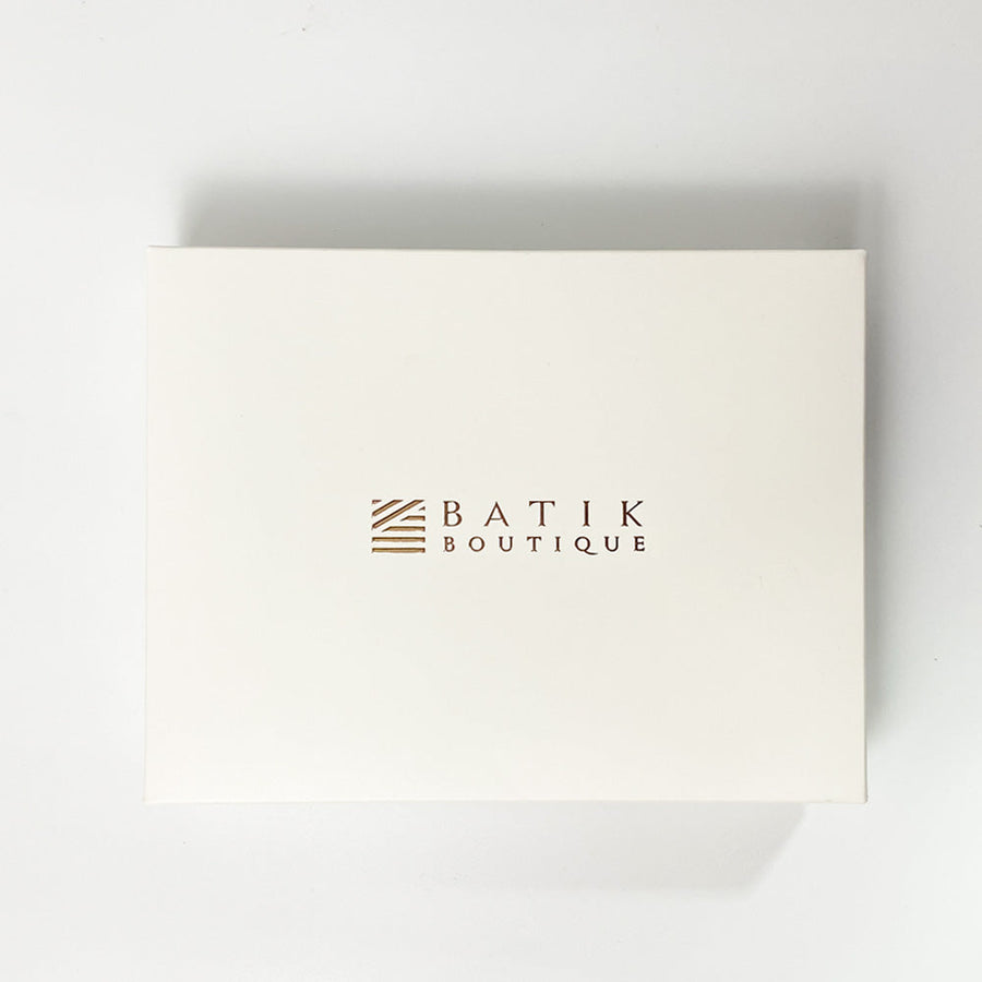A white box photo showing white box with Batik Boutique rose gold on top of the box