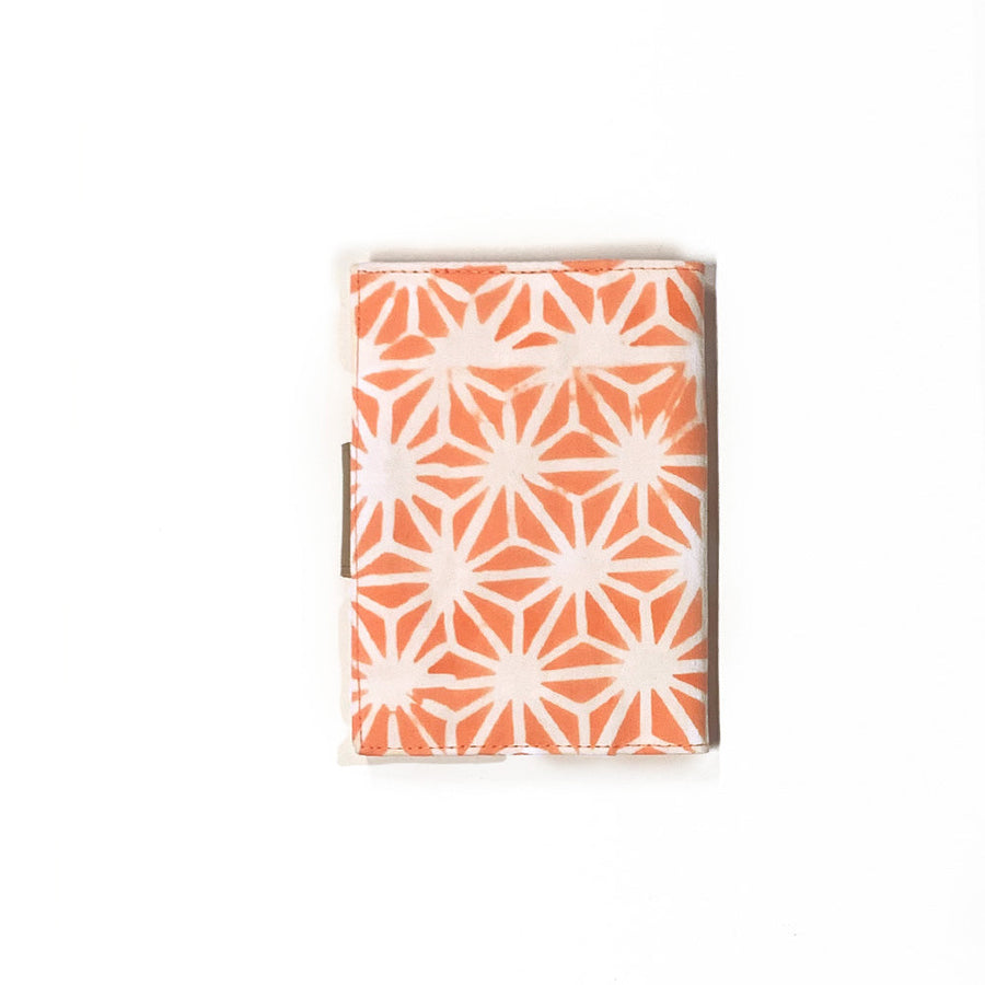 a back view of a passport cover made of batik in the pattern peach firework