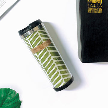 a lifestyle photo of a sage banana leaf tumbler made of batik against a neutral background