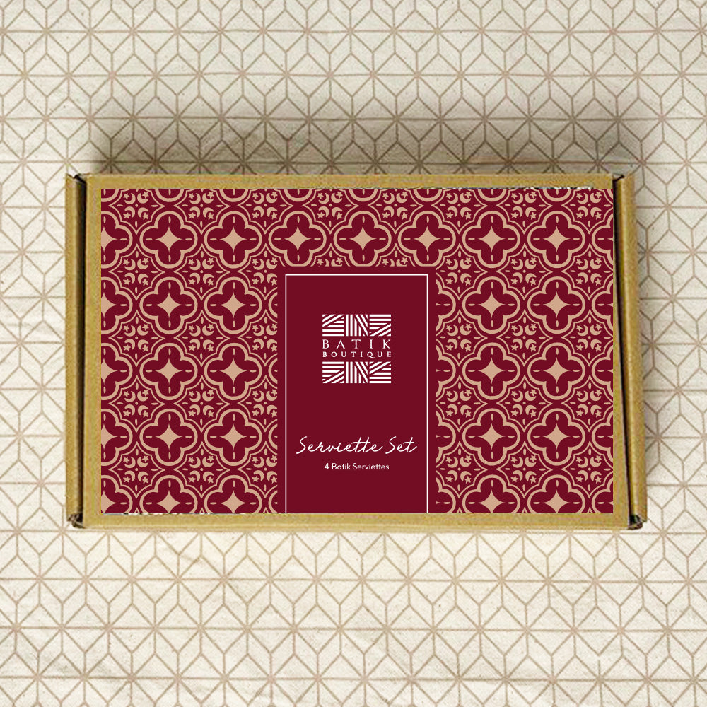 A lifestyle photo of box of serviette set in crimson celestial  with pattern of batik boutique as a background