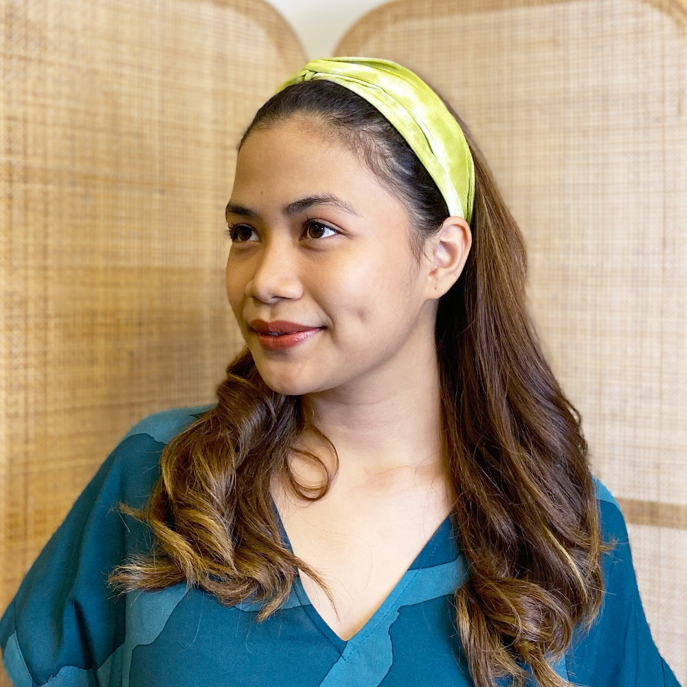 A woman is wearing shibori headband in green color shibori made by remnant shibori fabric for more sustainable approach