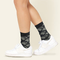 a photo of model wearing black sock which is the pattern is inspired from batik.