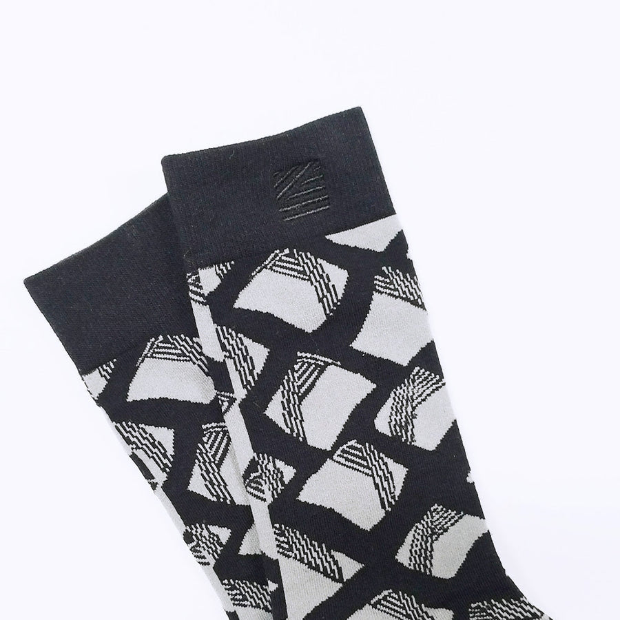 a closeup photo of whitebox of black and grey motif socks inspired by batik