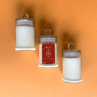 an orange and clove scented candle in front of an orange wall