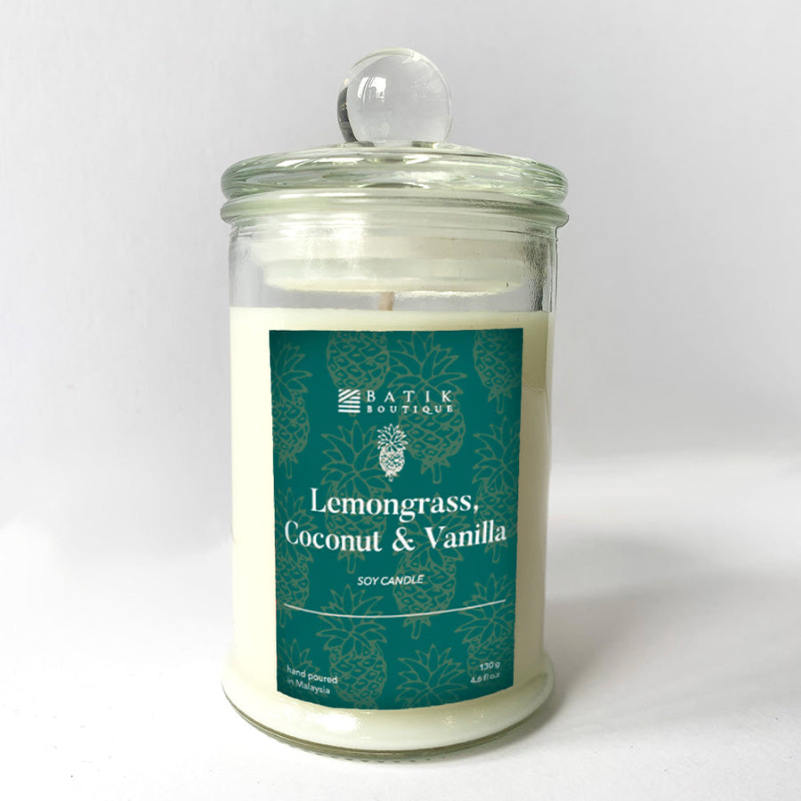 a lemongrass, coconut and vanilla scented candle in front of a white wall