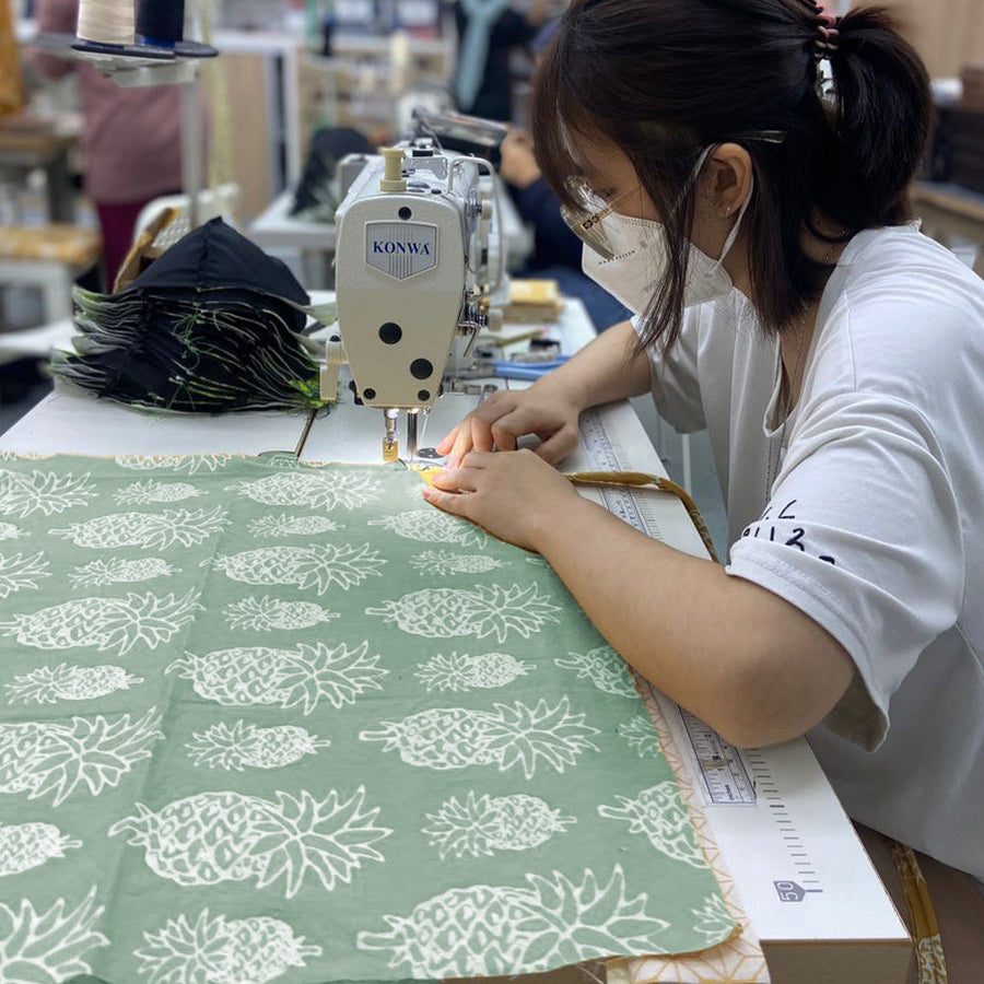 an seamstress sewing olive pineapple
